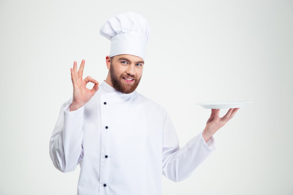Portrait of a man chef showing ok sign and empty plate isolated on a white background Portrait of a man chef showing ok sign and empty plate isolated on a white background